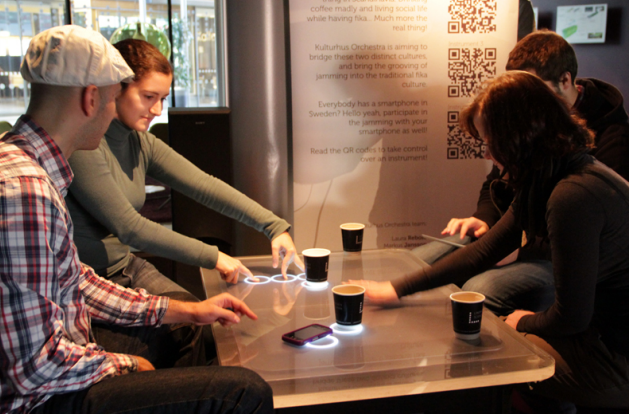 4 people in a coffee shop around a table